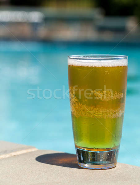 glass of beer on edge by poolside stock photo backyard