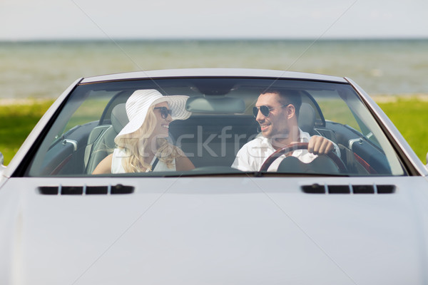 leisure, road trip, dating, couple and people concept - happy man and woman driving in cabriolet car outdoors