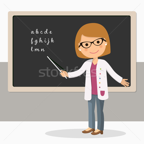 young female teacher on alphabet lesson at blackboard in
