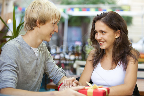 stock photo: the young man gives a gift to a young girl in the