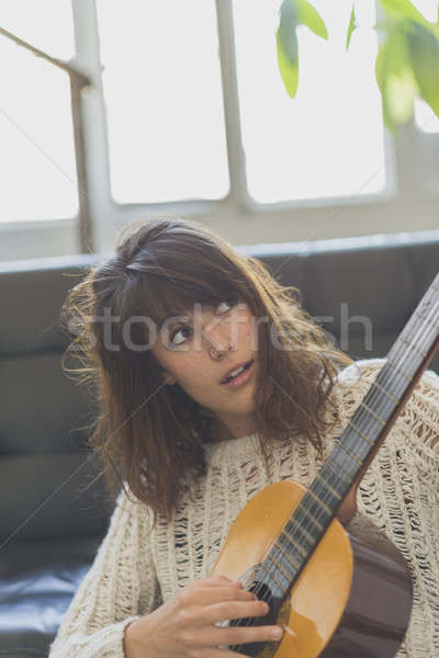 Mooie jonge vrouw vergadering sofa spelen gitaar Stockfoto © 2Design