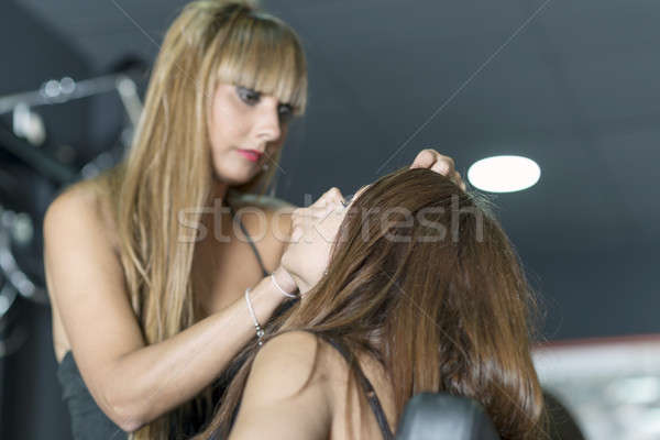 Young makeup artist doing makeover to pretty model Stock photo © 2Design