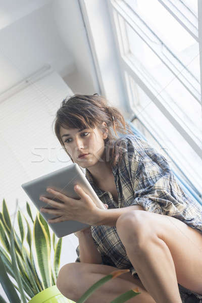 Woman on house stairs relaxing, reading email on a tablet Stock photo © 2Design