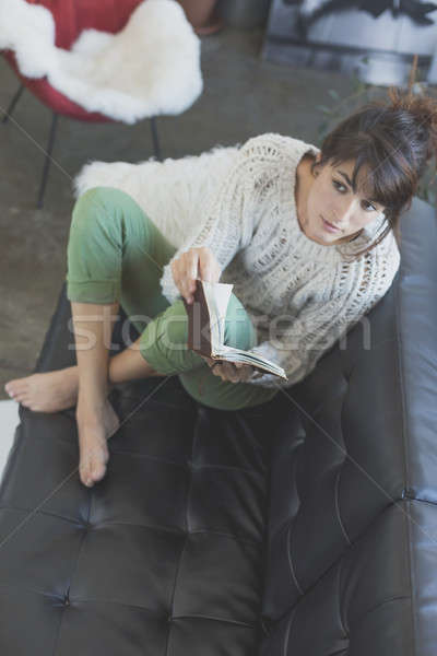 Woman lying on a sofa and reading a book Stock photo © 2Design