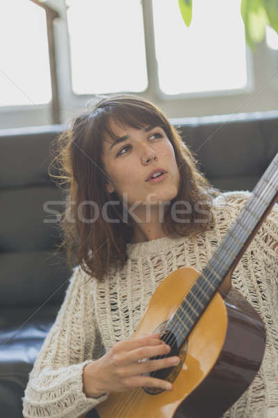 Mooie jonge vrouw vergadering sofa spelen gitaar Stockfoto © 2Design