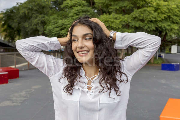 Black hair woman hands over head looking at side sitting outdoor Stock photo © 2Design