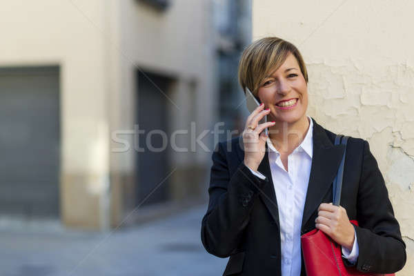 Executive talking on phone looking at camera on the street Stock photo © 2Design