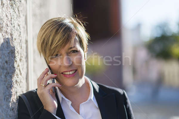 Executive talking on phone looking at camera on the street Stock photo © 2Design