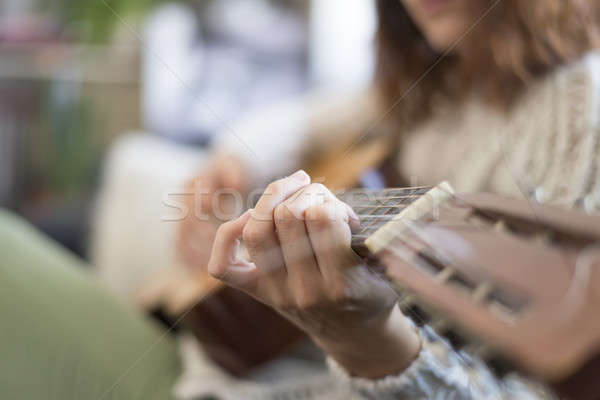 Mooie jonge vrouw vergadering sofa spelen gitaar Stockfoto © 2Design