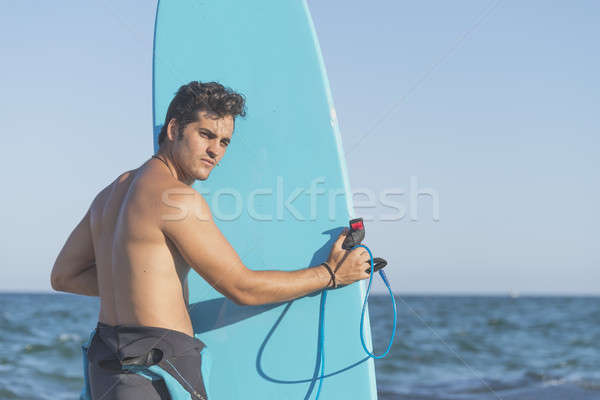 Young attractive surfer holding his surfboard at the beach Stock photo © 2Design