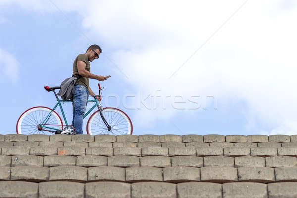 Trendy man using his smartphone outdoors Stock photo © 2Design