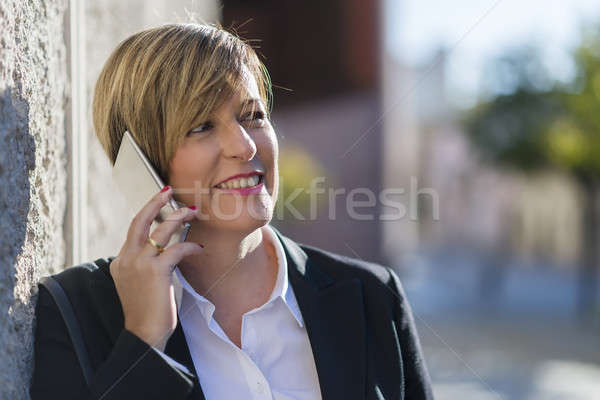 Executive talking on phone looking at camera on the street Stock photo © 2Design