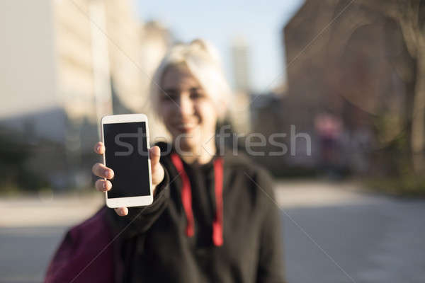Front view of a happy girl showing a blank smart phone display a Stock photo © 2Design