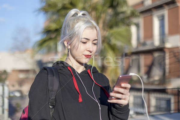 Handsome smiling woman with mobile phone walking on the street Stock photo © 2Design