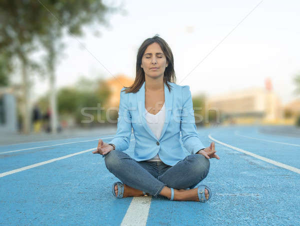 woman meditating yoga in lotus position on a athletics court Stock photo © 2Design