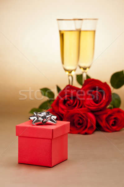 Stock photo: Champagne glasses, present and roses