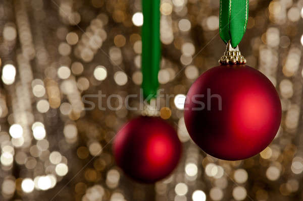 Two red Christmas baubles in front of a gold glitter background Stock photo © 3523studio