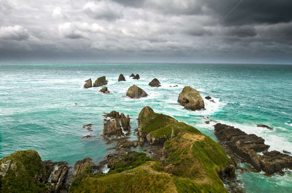 Cliffs under thunder clouds and turquoise ocean Stock photo © 3523studio