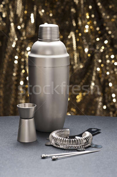 Stock photo: Bartender tools in front of a gold glitter background