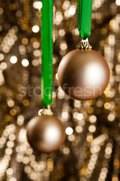 Two gold Christmas baubles in front of a gold glitter background Stock photo © 3523studio