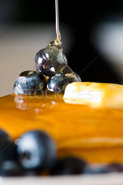 Stock photo: Blueberry butter pancake with honey/ maple sirup flowing down