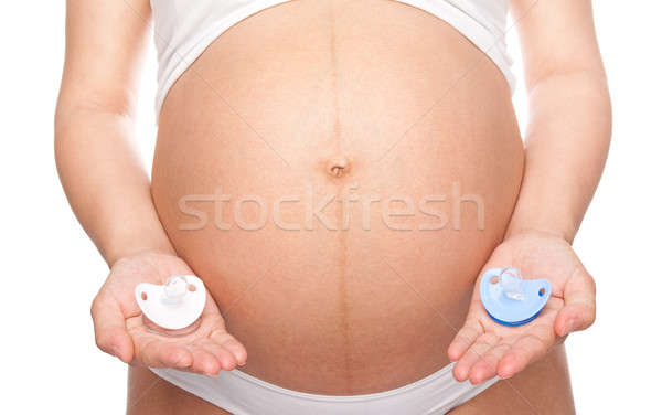 Pregnant woman holding pacifiers Stock photo © 3dvin