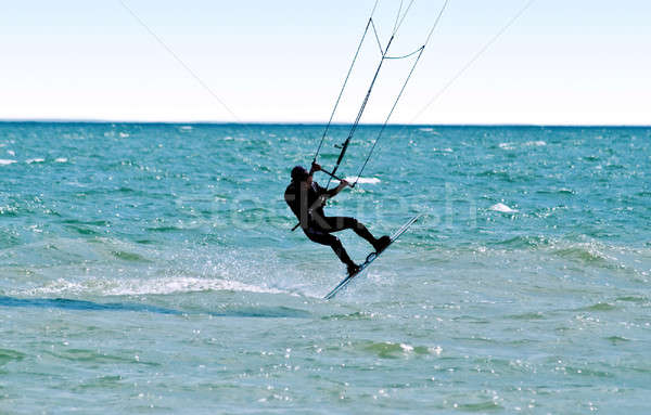 Silhouette of a kitesurfer on waves of a sea Stock photo © acidgrey