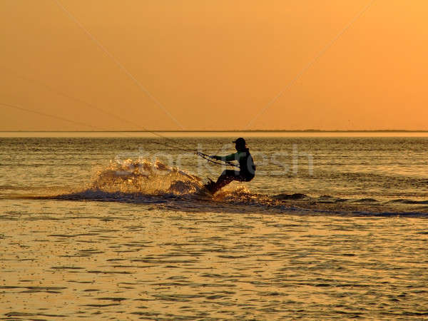 Silhouette of a kitesurf on a gulf on a sunset 2 Stock photo © acidgrey