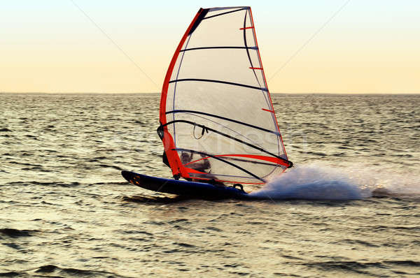 Stock photo: Silhouette of a windsurfer on a gulf, moving at great speed
