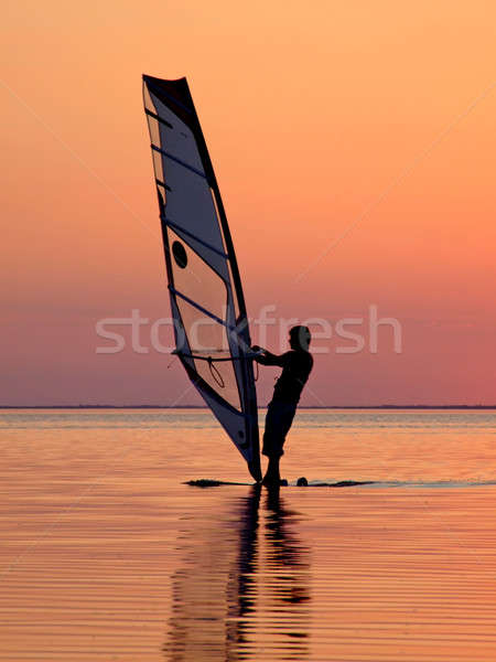 Silhouette of a wind-surfer on waves of a gulf on a sunset 3 Stock photo © acidgrey