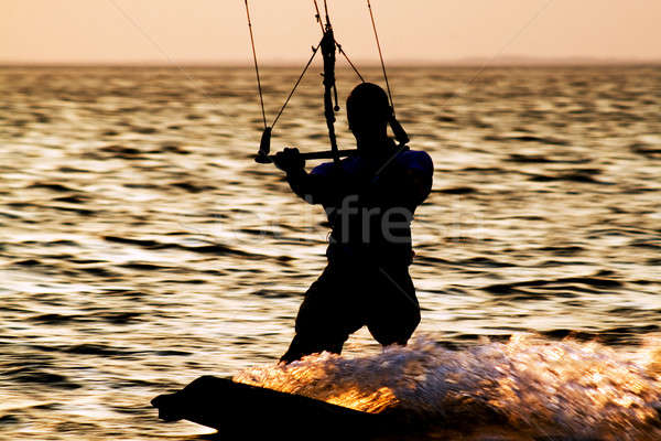 Stock photo: Silhouette of a kitesurfer on a gulf