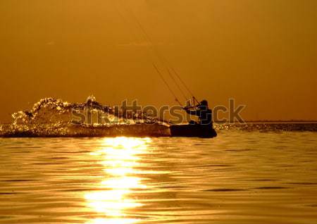 Silhouette of a kite-surf on waves of a gulf on a sunset 2 Stock photo © acidgrey