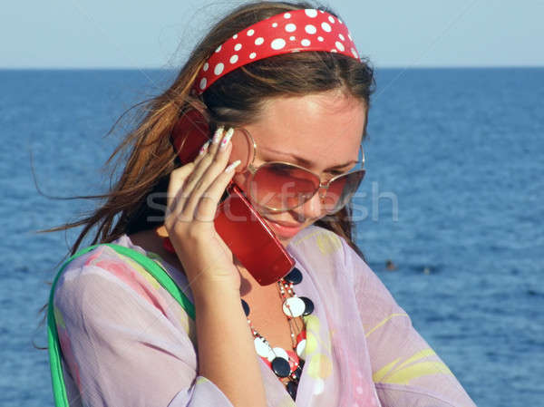 The beautiful girl talks by a mobile phone on the sea Stock photo © acidgrey