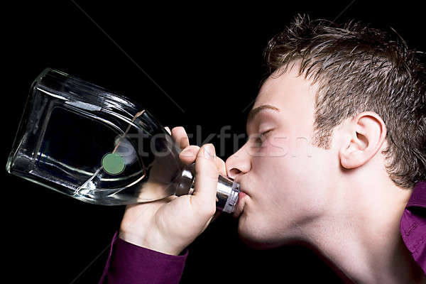 Junger Mann Getränke Wodka Flasche isoliert schwarz Stock foto © acidgrey