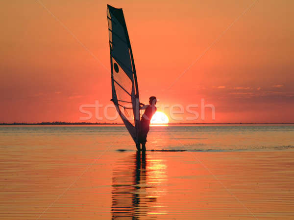 Silhouette of a windsurfer on waves of a gulf on a sunset 4 Stock photo © acidgrey