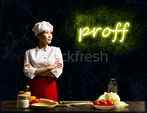 Stock photo: Asian female chef looking at the glowing proff