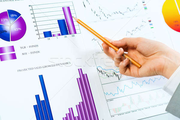 female hand pointing pencil on financial charts Stock photo © adam121