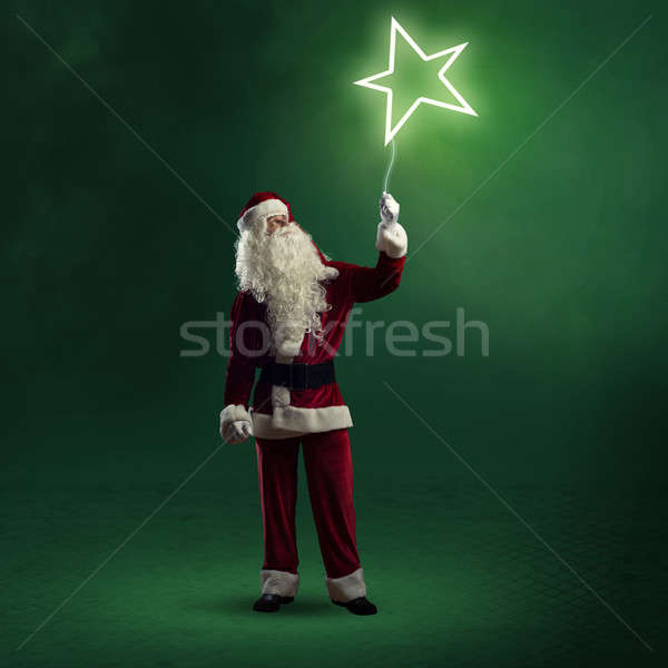 Santa Claus is holding a shining star Stock photo © adam121