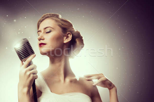 Stock photo: attractive female singer with microphone