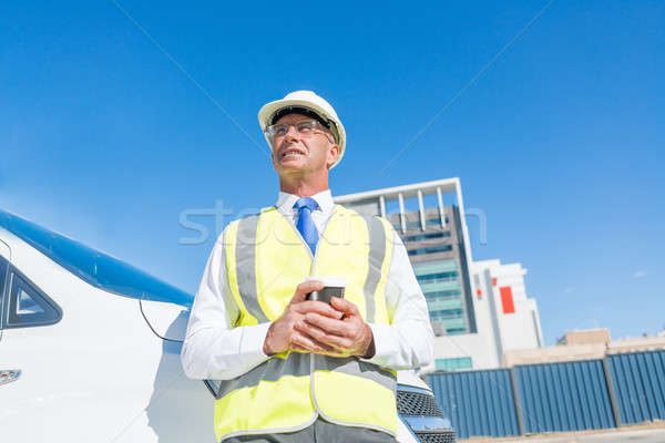 Engineer builder on construction site at sunny day with coffee in hand Stock photo © adam121