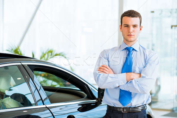 dealer stands near a new car in the showroom Stock photo © adam121