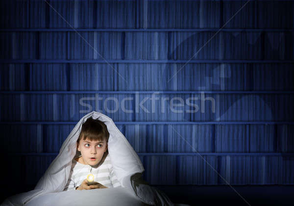 Stock photo: boy under the covers with a flashlight