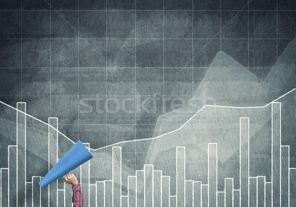 Hand of woman holding blue paper trumpet against graphs background Stock photo © adam121