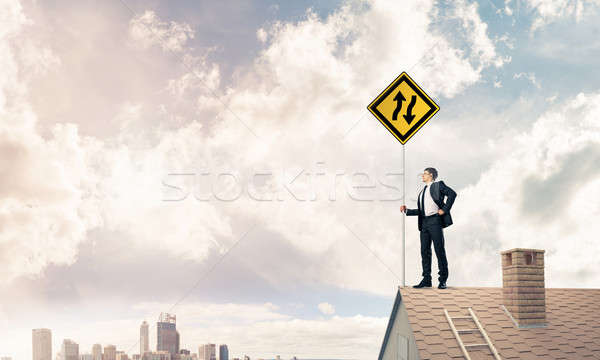 Stock photo: Mister boss on brick roof with sign in hands. Mixed media