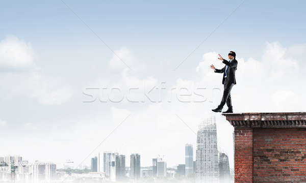 Stock photo: Danger and risk concept with businessman making step from edge