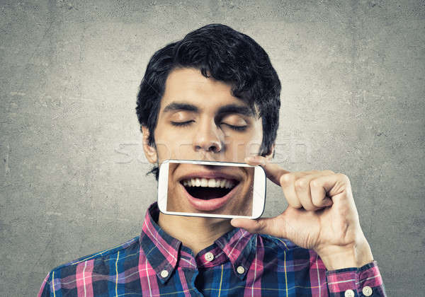 Férfi mobiltelefon fiatalember tart okostelefon mosoly Stock fotó © adam121