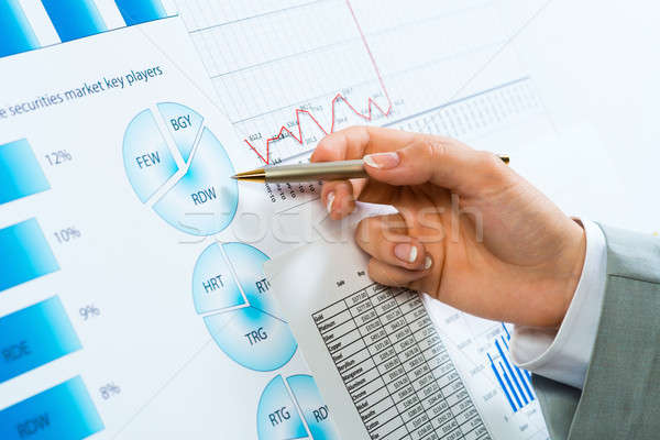 female hand pointing pen on financial charts Stock photo © adam121