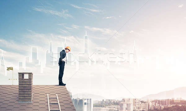 Engineer man standing on roof and looking down. Mixed media Stock photo © adam121