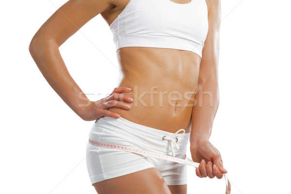 Stock photo: young athletic woman measuring waist