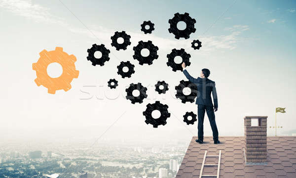 Businessman standing with back on house brick roof and drawing.  Stock photo © adam121